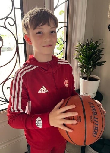 Luka shown wearing his MedicAlert wristband and holding a basketball