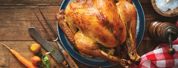 Roasted turkey on table with carving utensils