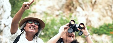 Man and woman with binoculars looking up