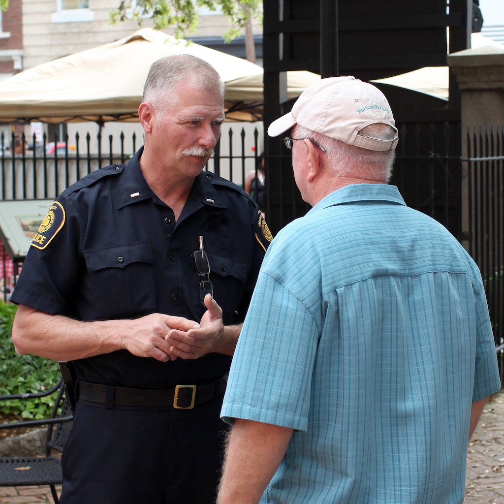 Police office speaking with man