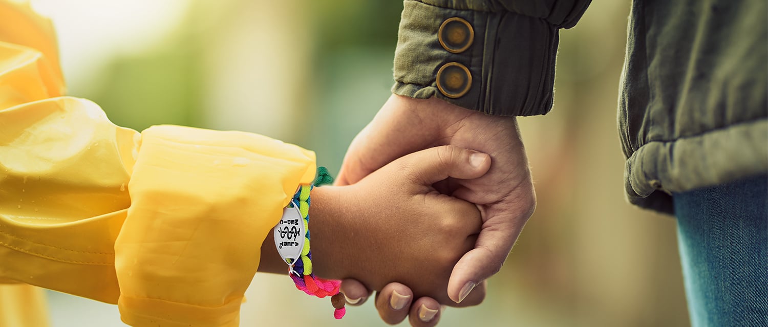 Parent walking and holding little girl's hand