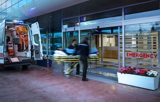 Ambulance and paramedics in front of an Emergency room entrance Ambulance and paramedics in front of an Emergency room entrance
