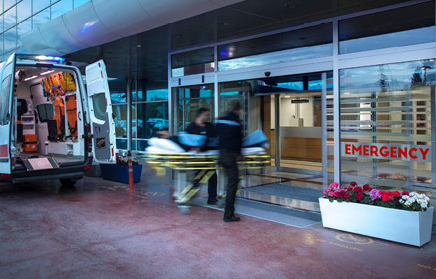 Ambulance and paramedics in front of an Emergency room entrance