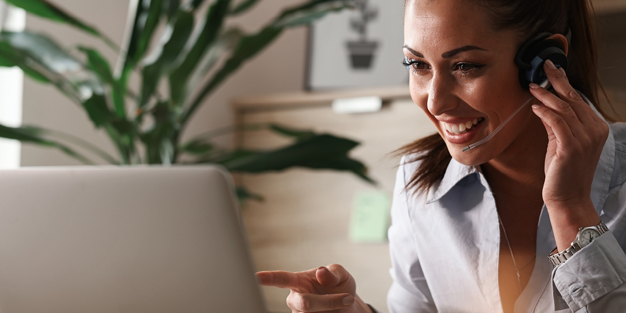 Woman with headset looking at a laptop Woman with headset looking at a laptop