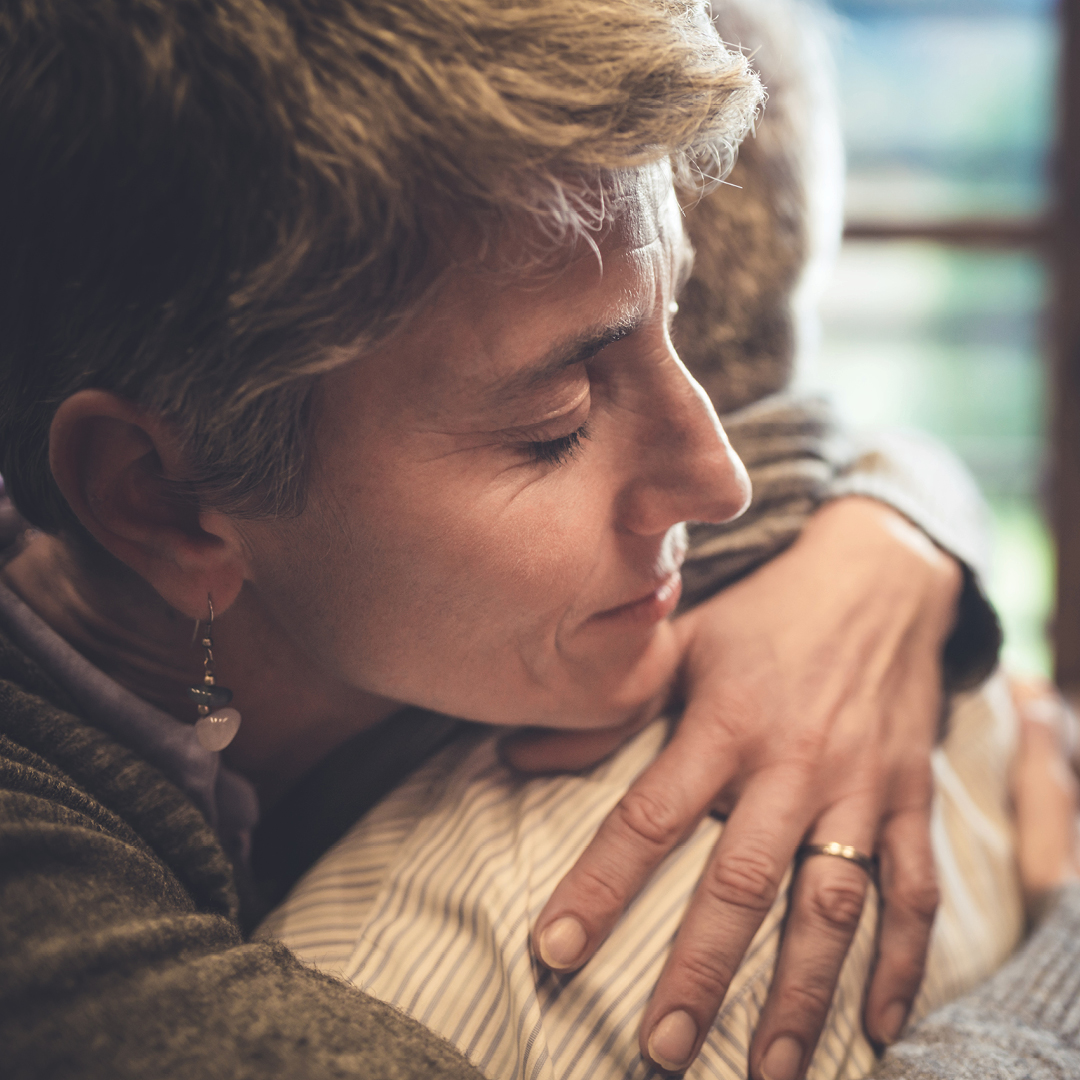 Daughter hugging elderly mother