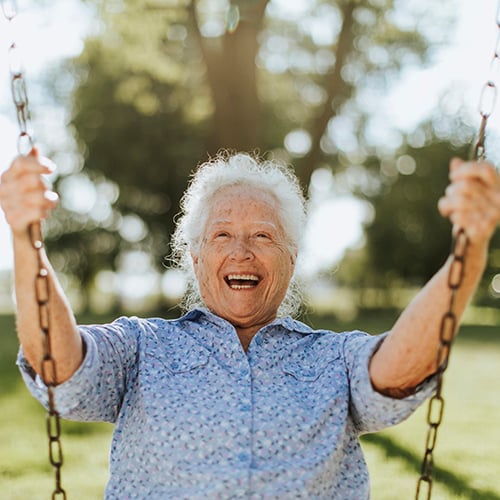 Une femme âgée heureuse sur une balançoire