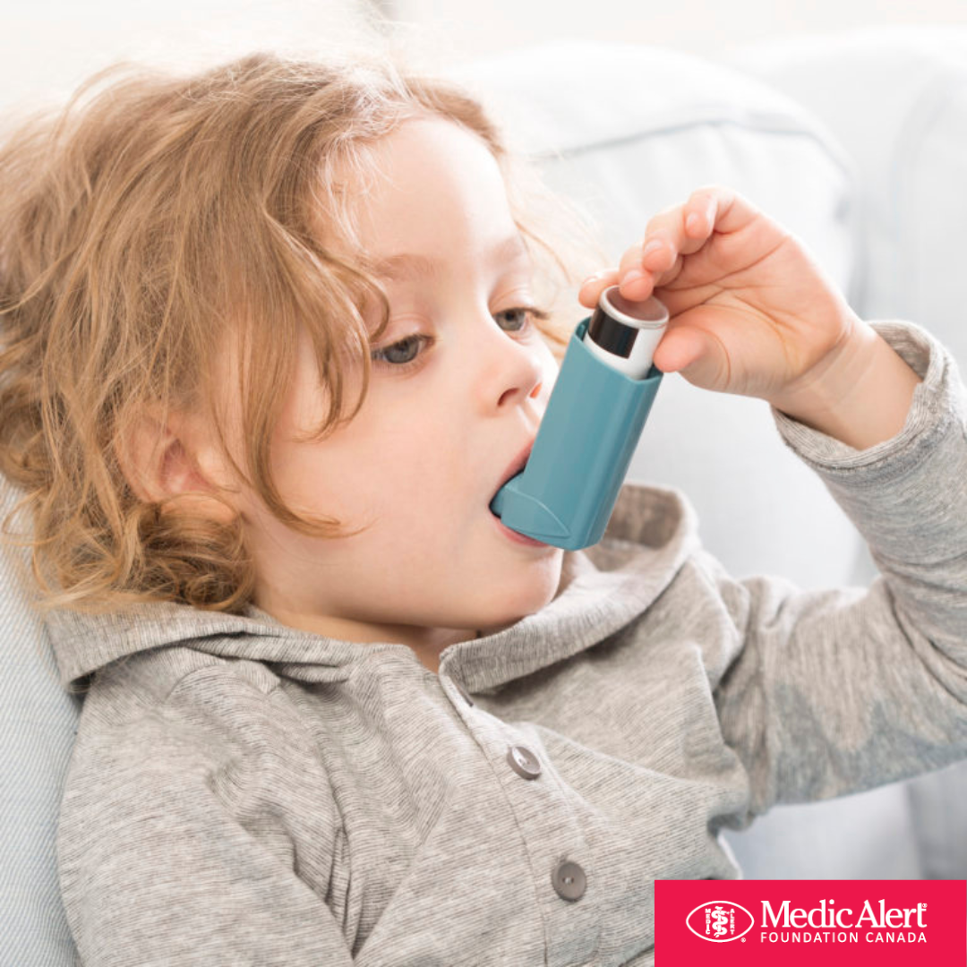 Child sitting on couch using asthma inhaler